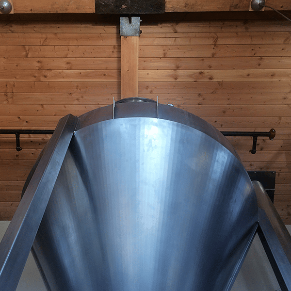 Carbon steel grist case hung over a mash tun
